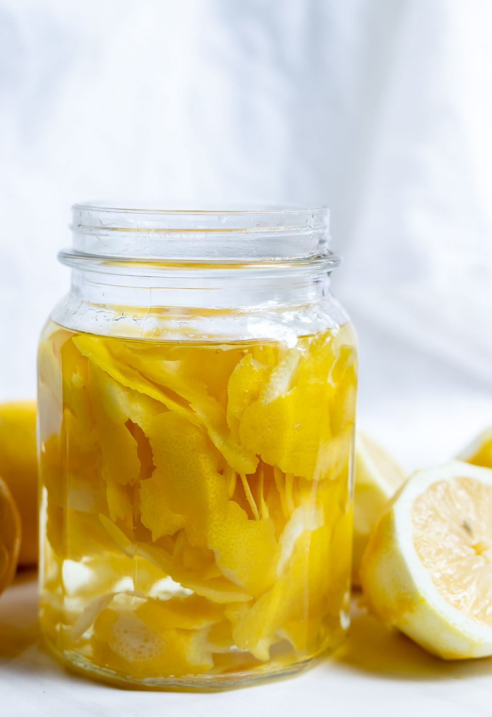 lemon peels and clear vinegar in glass jar