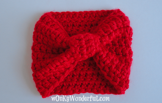 bright red crocheted cup cozy that looks like a bow