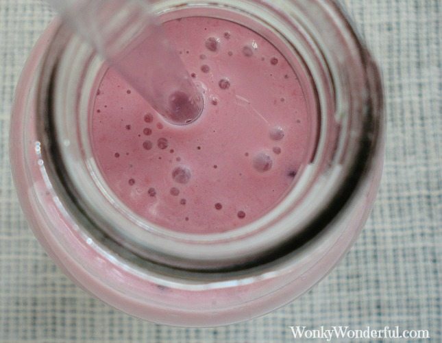 close up of pink smoothie in clear bottle with clear straw