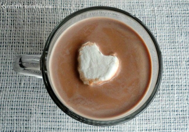 above view of hot chocolate and heart shaped marshmallow in glass mug