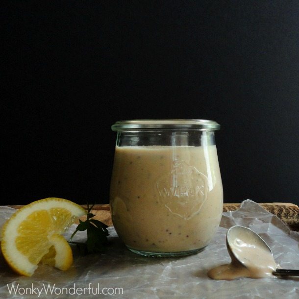 jar of creamy sauce with spoon and lemon wedge on the side