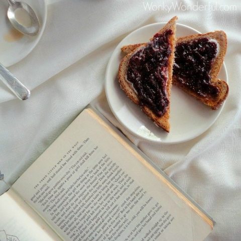 fig jam toast on white plate next to old book