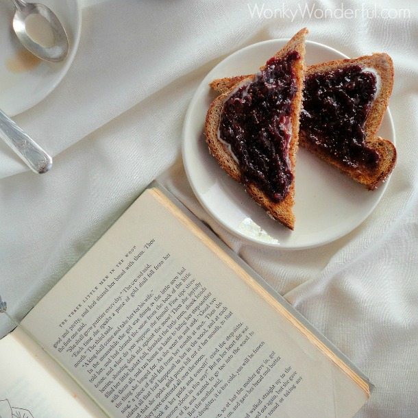 fig jam toast on white plate next to old book