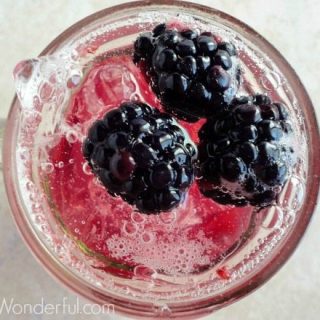 overhead photo of fizzy drink topped with fresh blackberries