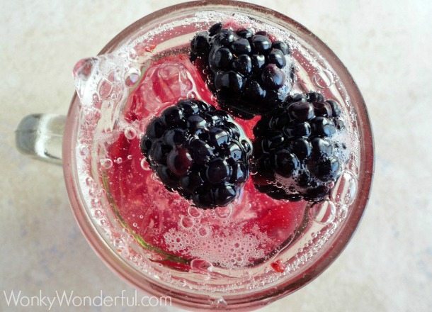 overhead photo of fizzy drink topped with fresh blackberries