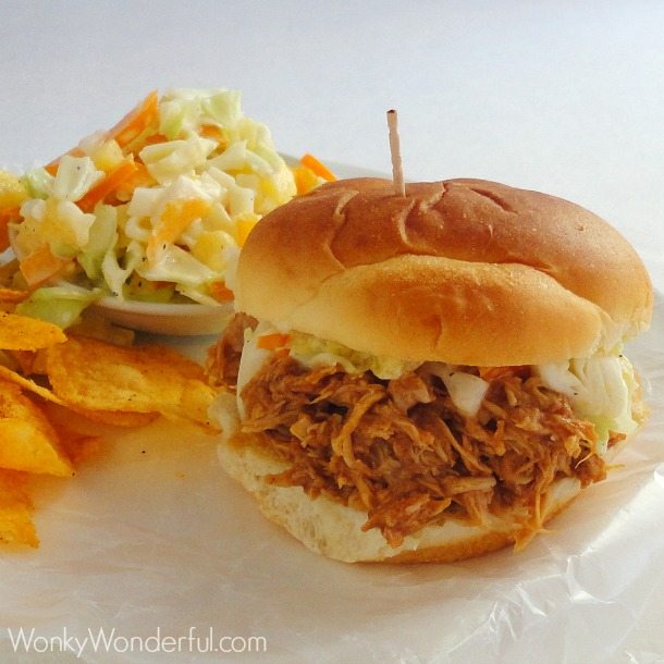 bbq chicken sandwich, slaw and chips on white plate