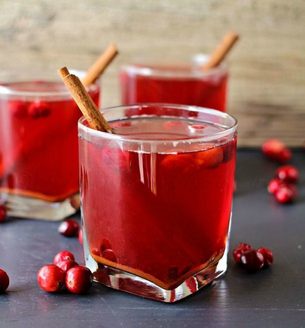 dark red drink with cinnamon sticks in clear glass