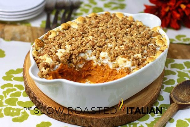 layered sweet potato casserole with a crumble top in a white casserole dish