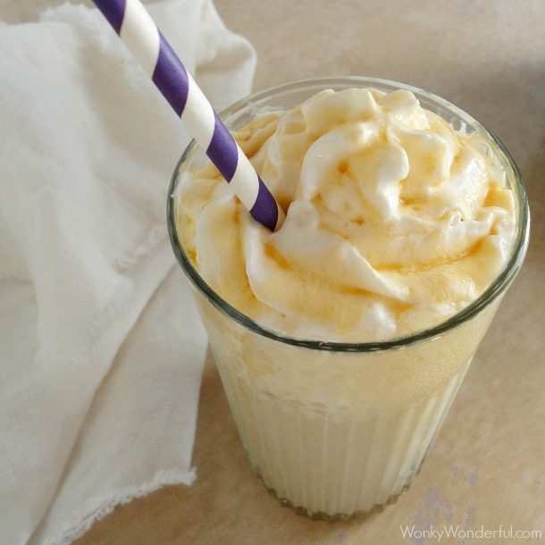 close up of creamy smoothie with purple and white striped straw