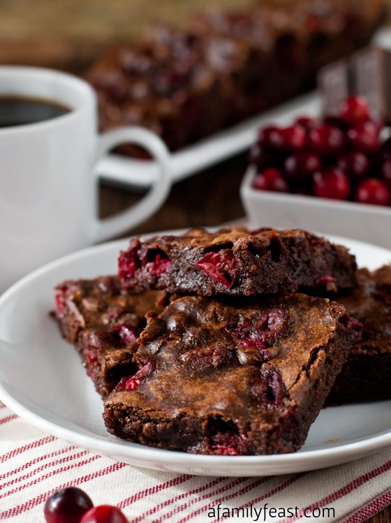 brown brownie squares with red chunks inside served on white plate
