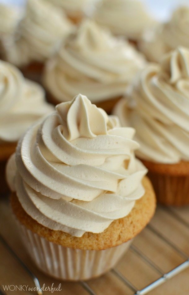 tan cupcakes topped with a swirl of buttercream frosting