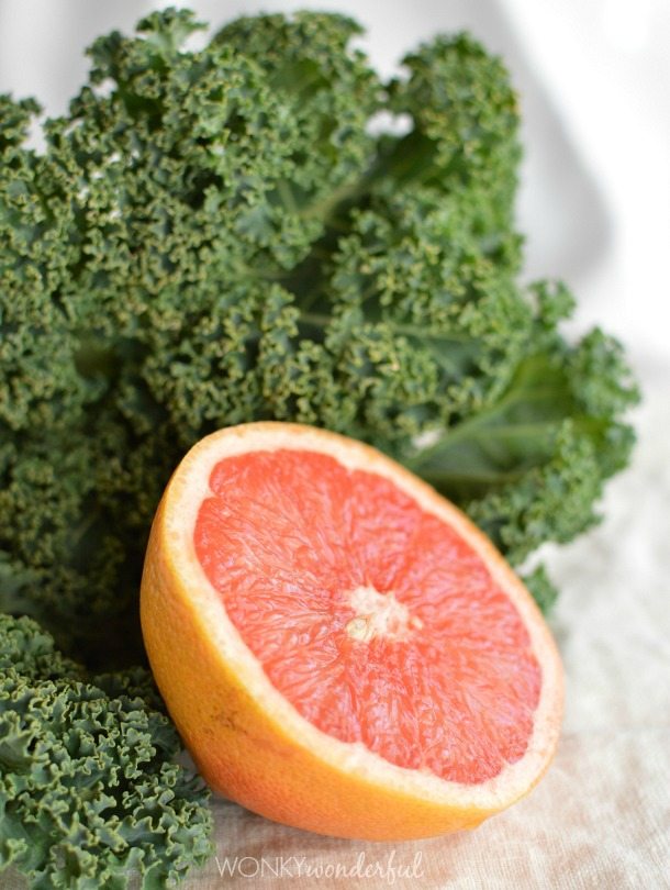 half a grapefruit next to fresh kale