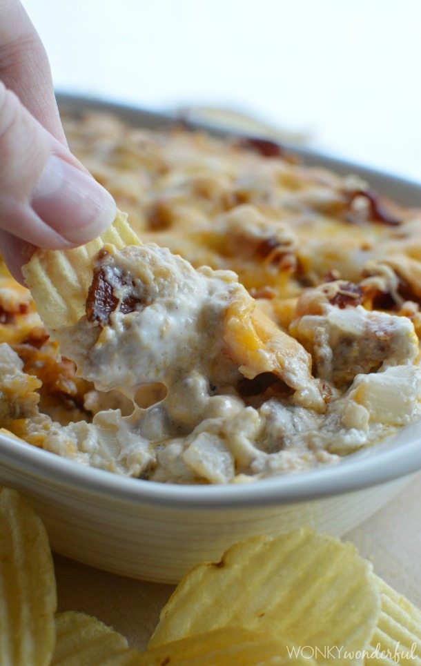hand scooping dip with ridged potato chip