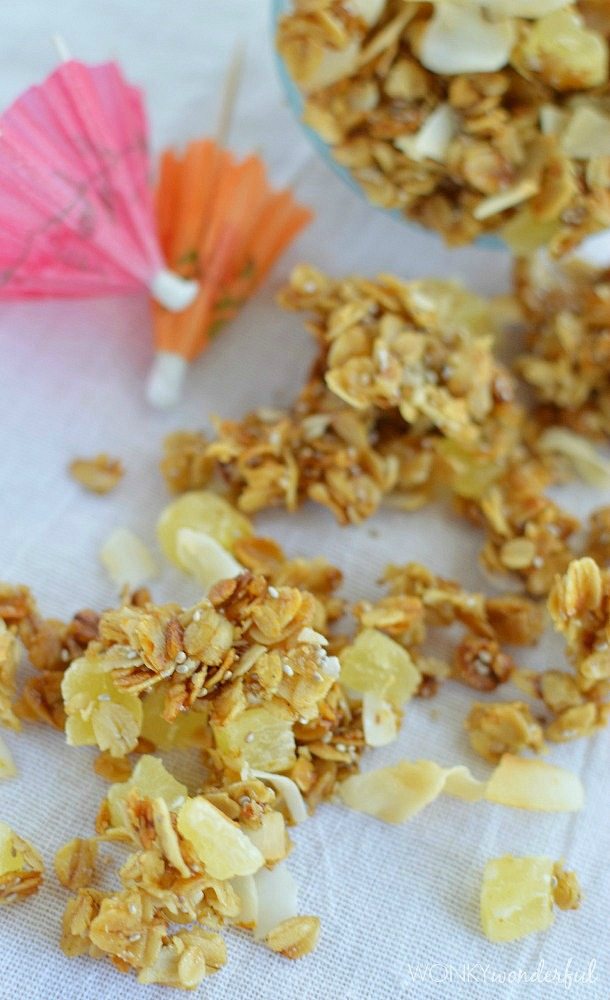 granola with dried pineapple chunks and coconut next to mini paper umbrellas