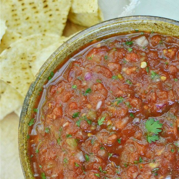 deep red salsa in brown bowl next to tortilla chips