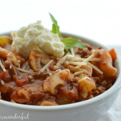 white bowl filled with saucy pasta topped with ricotta