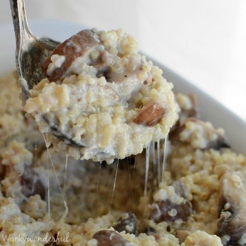 spoon scooping cheesy quinoa and mushrooms