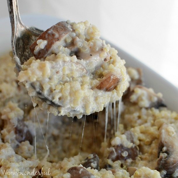 spoon scooping cheesy quinoa and mushrooms
