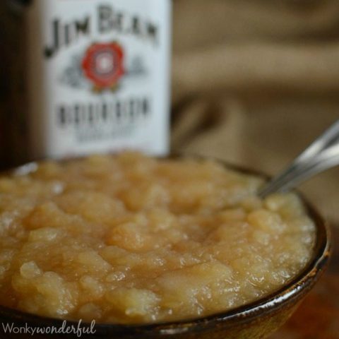 brown bowl filled with apple sauce, whiskey bottle in background