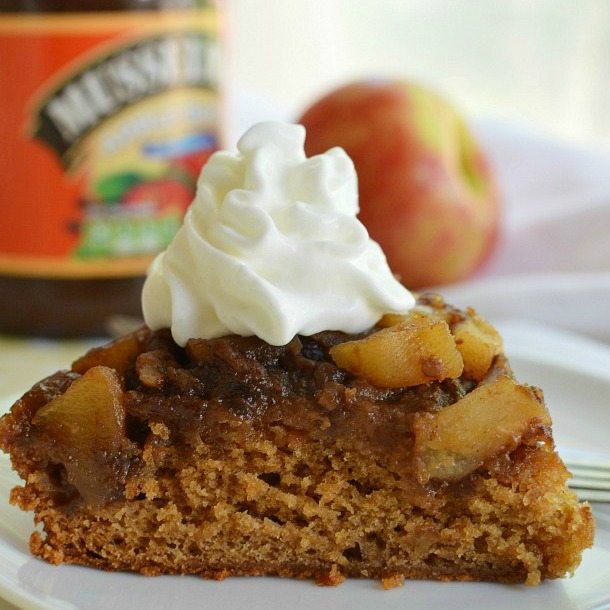 slice of brown cake with apple chunks topped with whipped cream