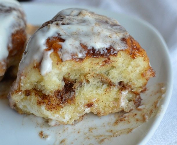 cinnamon roll cut into on white plate