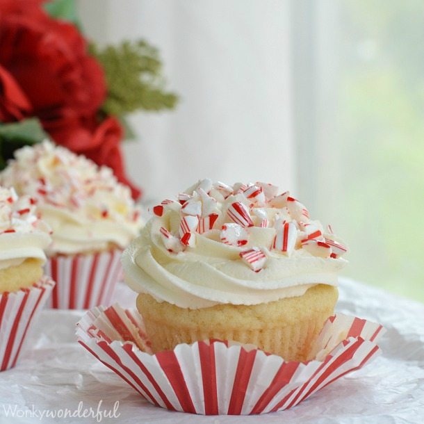 white cupcake with white frosting, red and white liner peeled off