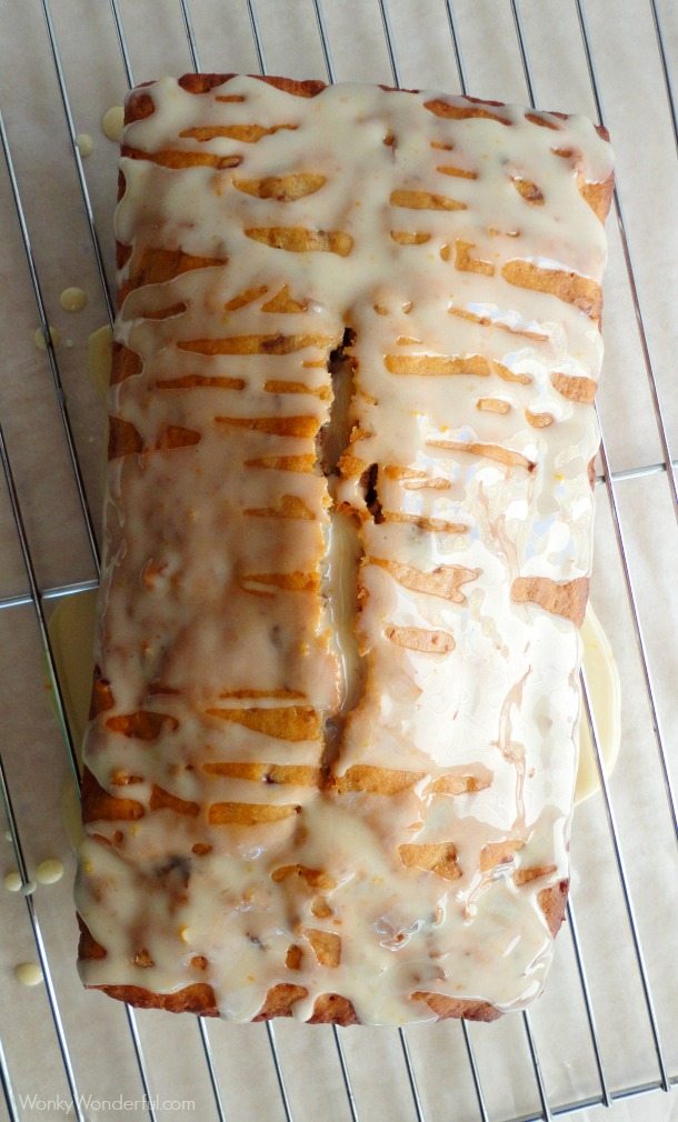 golden loaf drizzled with cream colored glaze on wire cooling rack