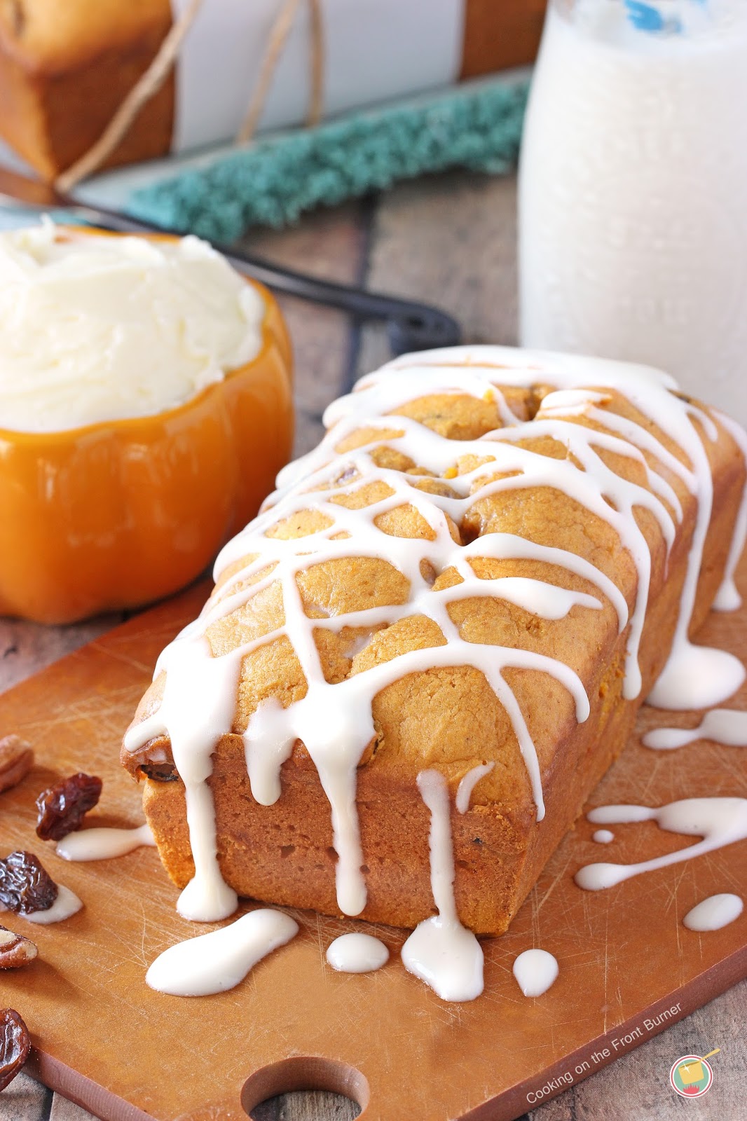 golden colored loaf drizzled with white glaze on wood board