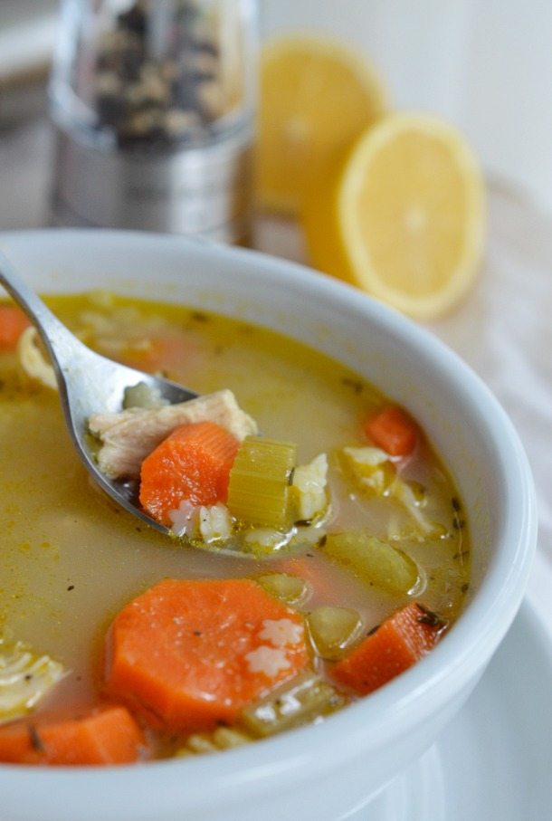 spoon scooping soup from white bowl