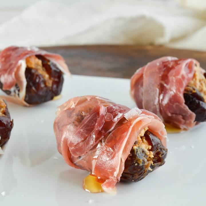 Prosciutto Wrapped Dated Stuffed with Goat Cheese and Fig Butter make the perfect hors d'oeuvres. Serve with a drizzle of honey and sprinkle of salt for the ultimate salty sweet appetizer recipe!