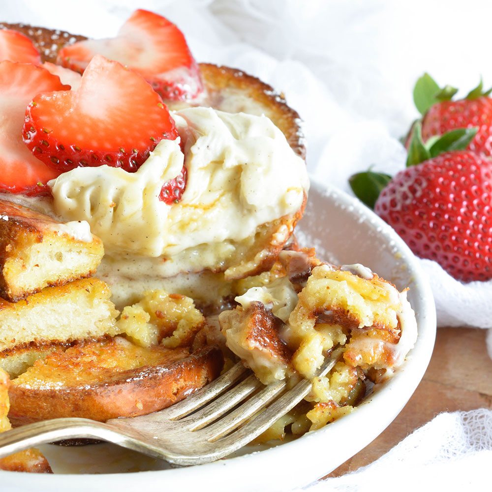 This Easy Baked French Toast Recipe is perfect for serving a crowd! Serve up this French Toast with Vanilla Mascarpone, Maple Syrup and Fresh Strawberries for the ultimate special occasion breakfast or brunch.