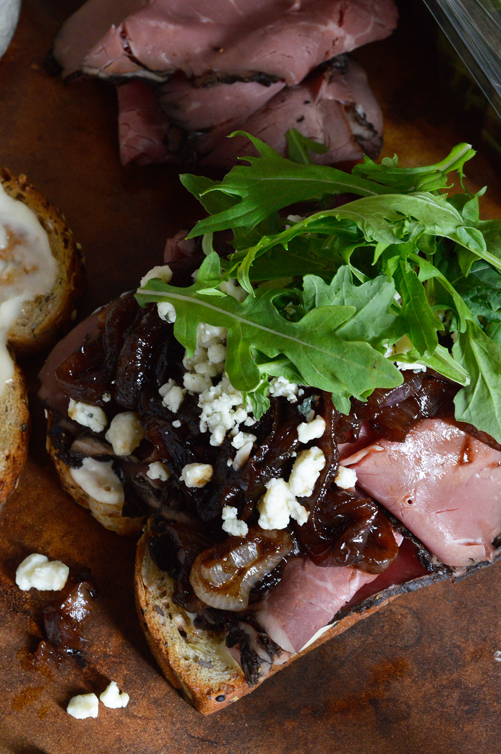 This Deli Style Roast Beef Sandwich is the best kind of lunch! Easy, delicious and flavorful. Deli roast beef, gorgonzola cheese, fresh greens and balsamic caramelized onions make this an amazing sandwich recipe!