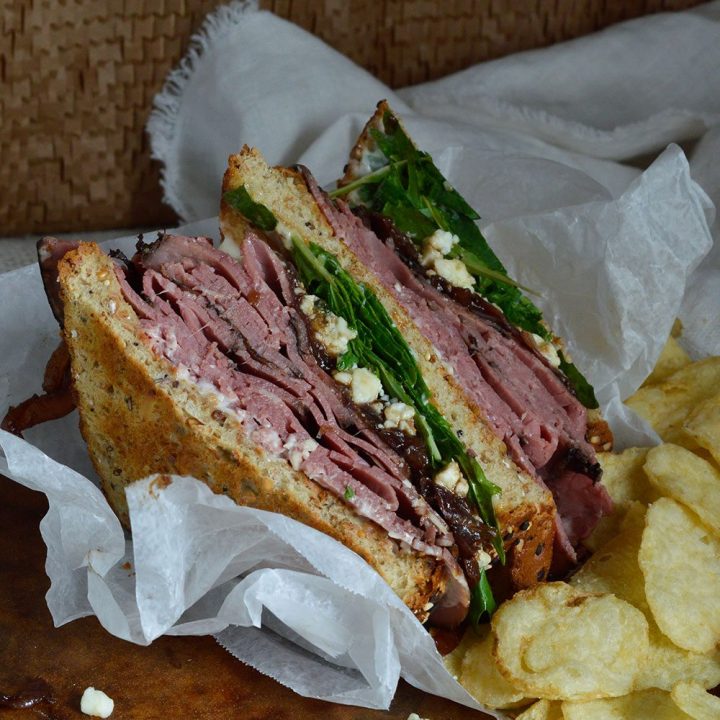 This Deli Style Roast Beef Sandwich is the best kind of lunch! Easy, delicious and flavorful. Deli roast beef, gorgonzola cheese, fresh greens and balsamic caramelized onions make this an amazing sandwich recipe!