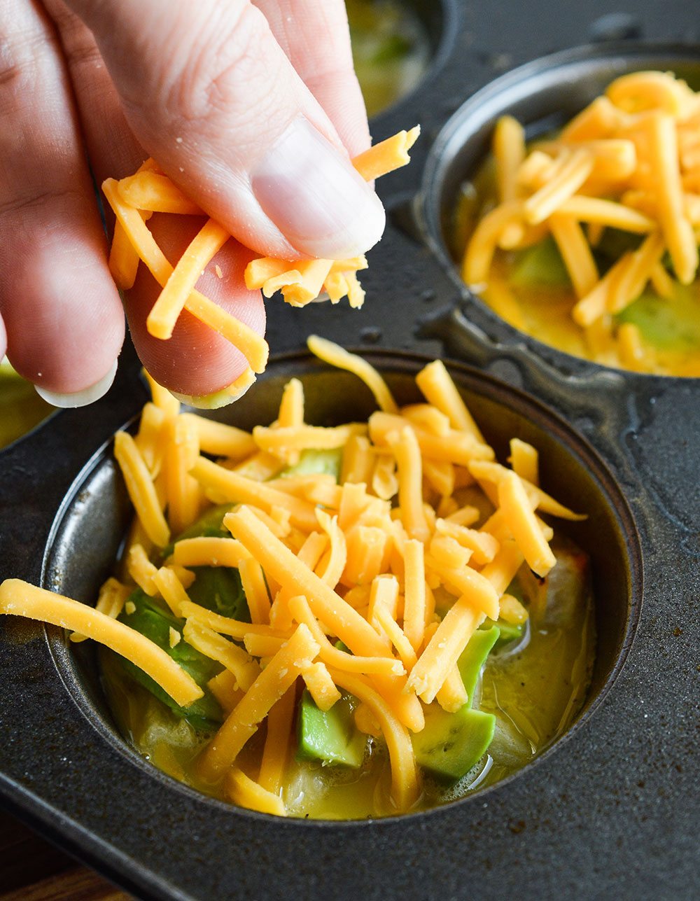 These Cheesy Avocado Egg Muffins are great for feeding a hungry breakfast or brunch crowd! All your favorite breakfast ingredients in one bite sized vegetarian egg muffin.