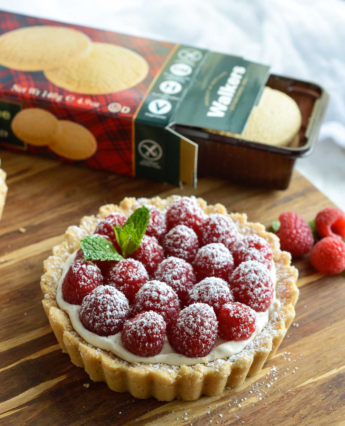 This Gluten Free Raspberry Tart Recipe will complete any holiday meal! A buttery gf tart crust filled with whipped vanilla cheesecake and topped with fresh raspberries. An easy, festive and delicious holiday dessert!