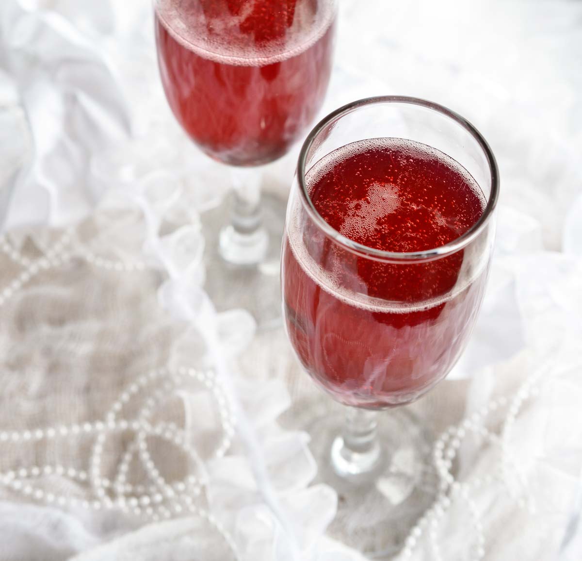 This Pomegranate Mimosa Recipe is perfect for New Year's Eve or brunch. A simple blend of champagne and pomegranate juice for a bubbly festive drink! Cheers!