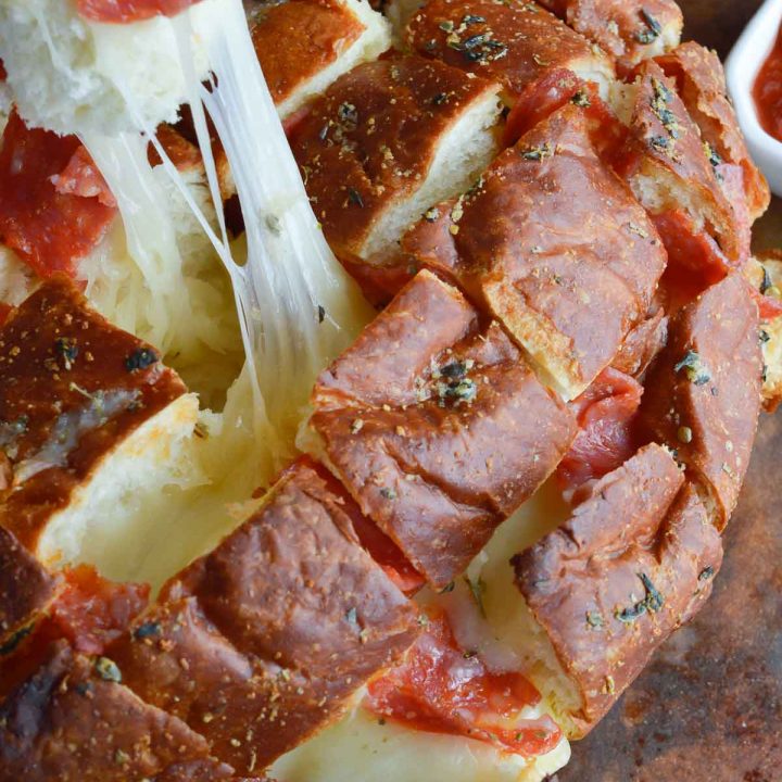 Perfect for any game day party, this Pull Apart Pizza Bread Recipe is super easy! Soft Hawaiian bread stuffed with pepperoni and cheese makes a fantastic appetizer!