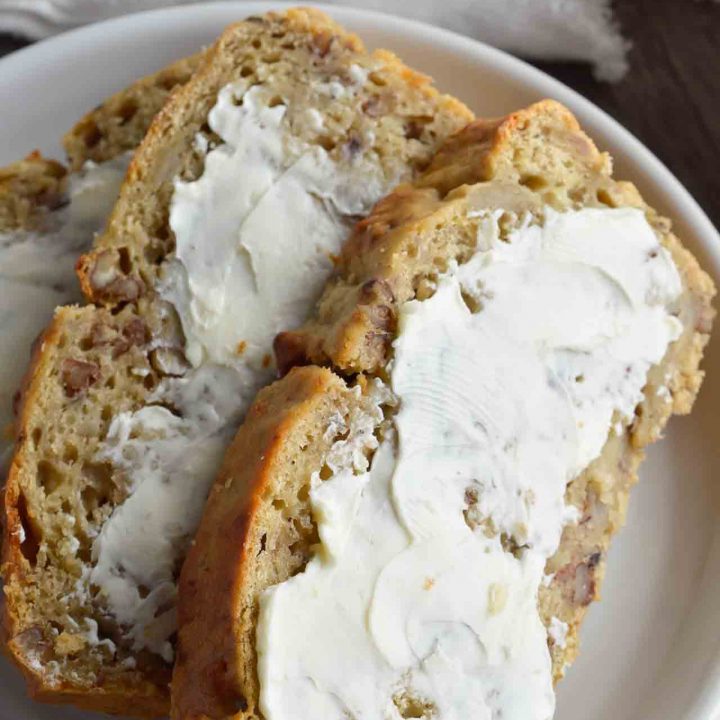 Say goodbye to dry, hard to swallow chunks of banana bread. This Super Moist Banana Bread Recipe is made with Greek yogurt and roasted bananas. This flavorful quick bread is perfect for dessert, breakfast or a snack!