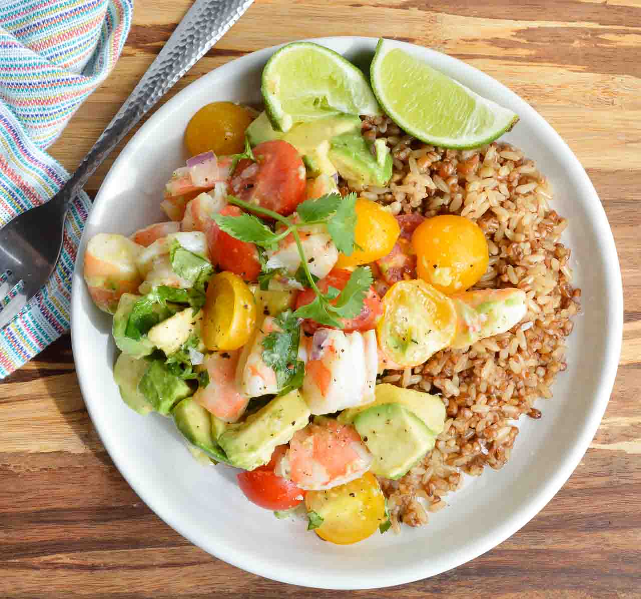 Craving a bright and flavorful meal that id full of fresh ingredients? Make this healthy Avocado and Shrimp Salad Recipe for a nutritious and satisfying lunch or dinner! Serve this fresh avocado, tomatoes, lime, cilantro and shrimp on top of rice.