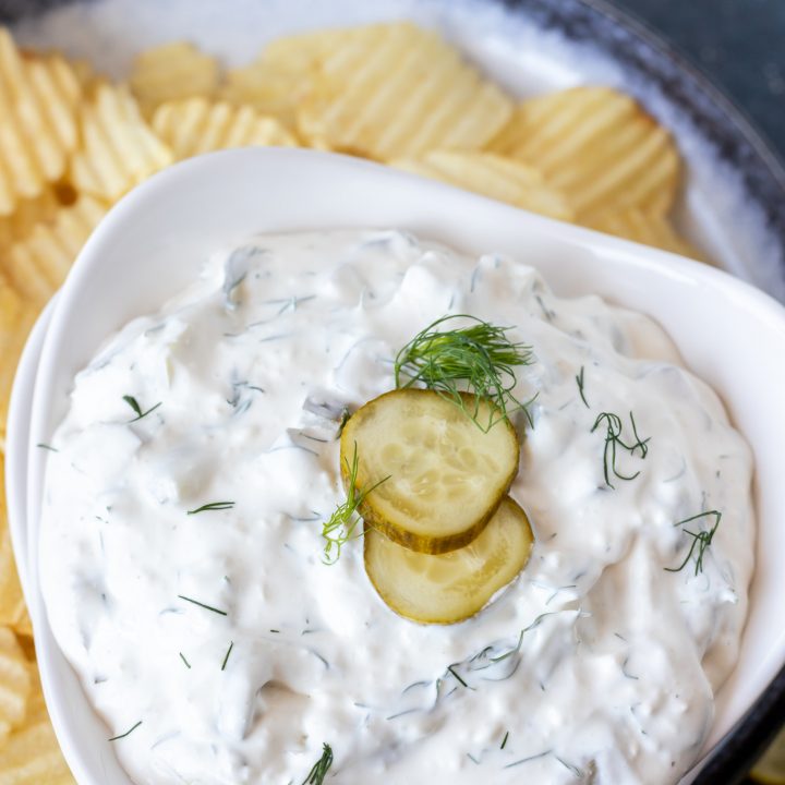 creamy dip topped with pickle slices and fresh dill