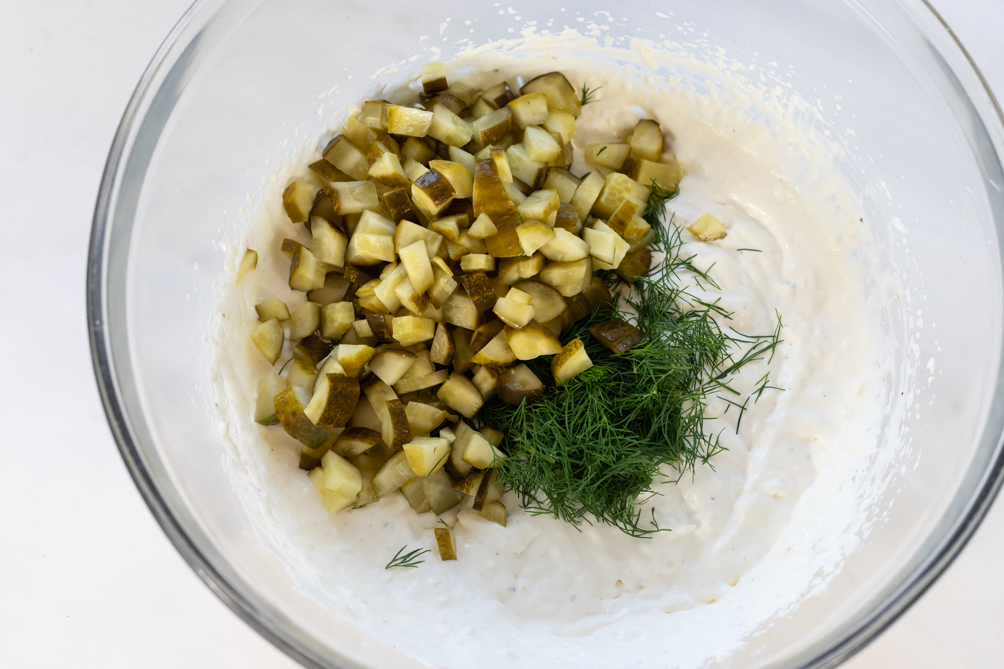 chopped pickles and dill in creamy base