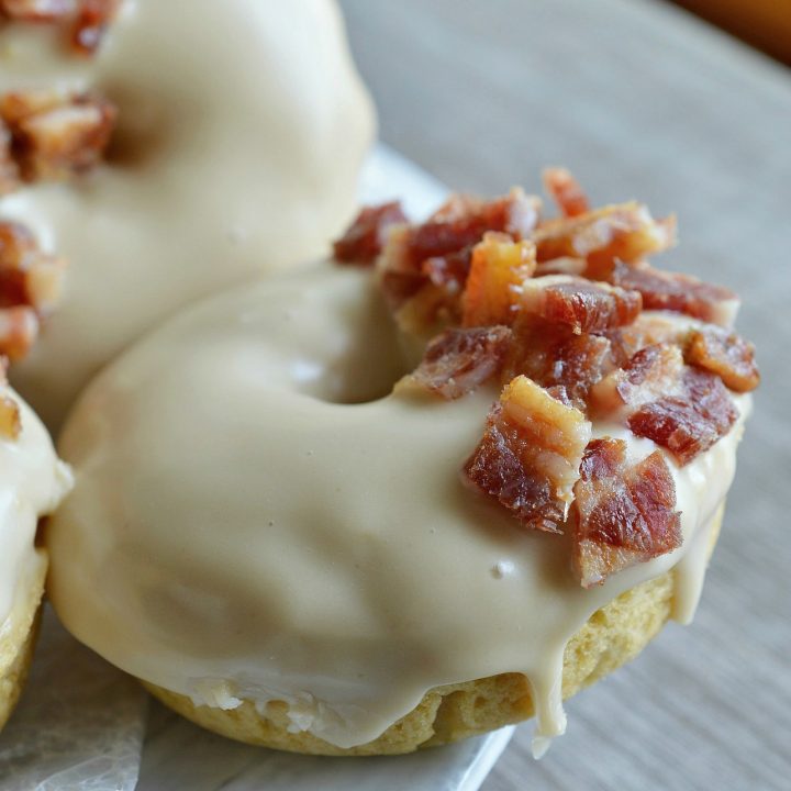 These Maple Bacon Donuts have to be one of the best flavor combinations ever! Brown sugar baked donuts with a pure maple syrup glaze then topped with brown sugar maple glazed bacon pieces. This breakfast recipe is the ultimate morning indulgence and perfection with a cup of coffee!