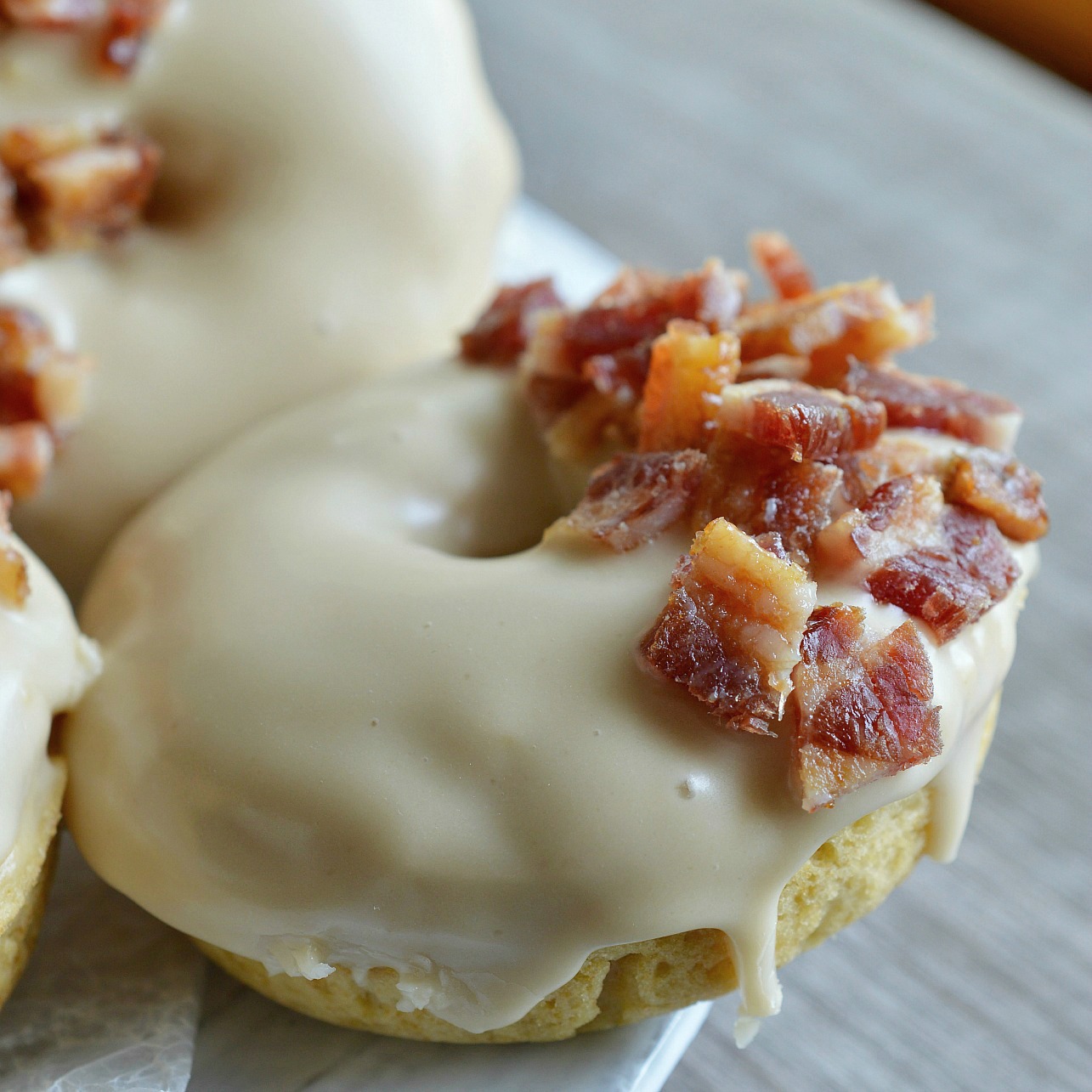 These Maple Bacon Donuts have to be one of the best flavor combinations ever! Brown sugar baked donuts with a pure maple syrup glaze then topped with brown sugar maple glazed bacon pieces. This breakfast recipe is the ultimate morning indulgence and perfection with a cup of coffee!