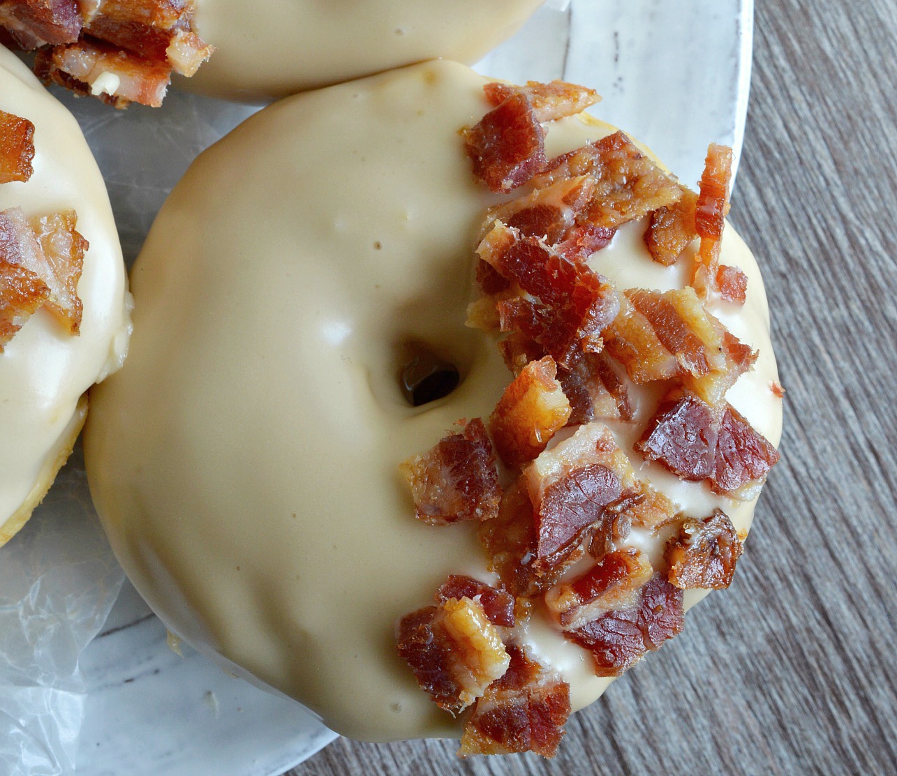 These Maple Bacon Donuts have to be one of the best flavor combinations ever! Brown sugar baked donuts with a pure maple syrup glaze then topped with brown sugar maple glazed bacon pieces. This breakfast recipe is the ultimate morning indulgence and perfection with a cup of coffee!