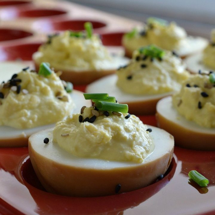 This deviled egg recipe is for the adventurous eater. Deviled Soy Sauce Eggs are first cooked in a soy sauce mixture then prepared into deviled eggs. Top with sesame seeds and chives. These eggs are full of Asian flair and unique flavor!