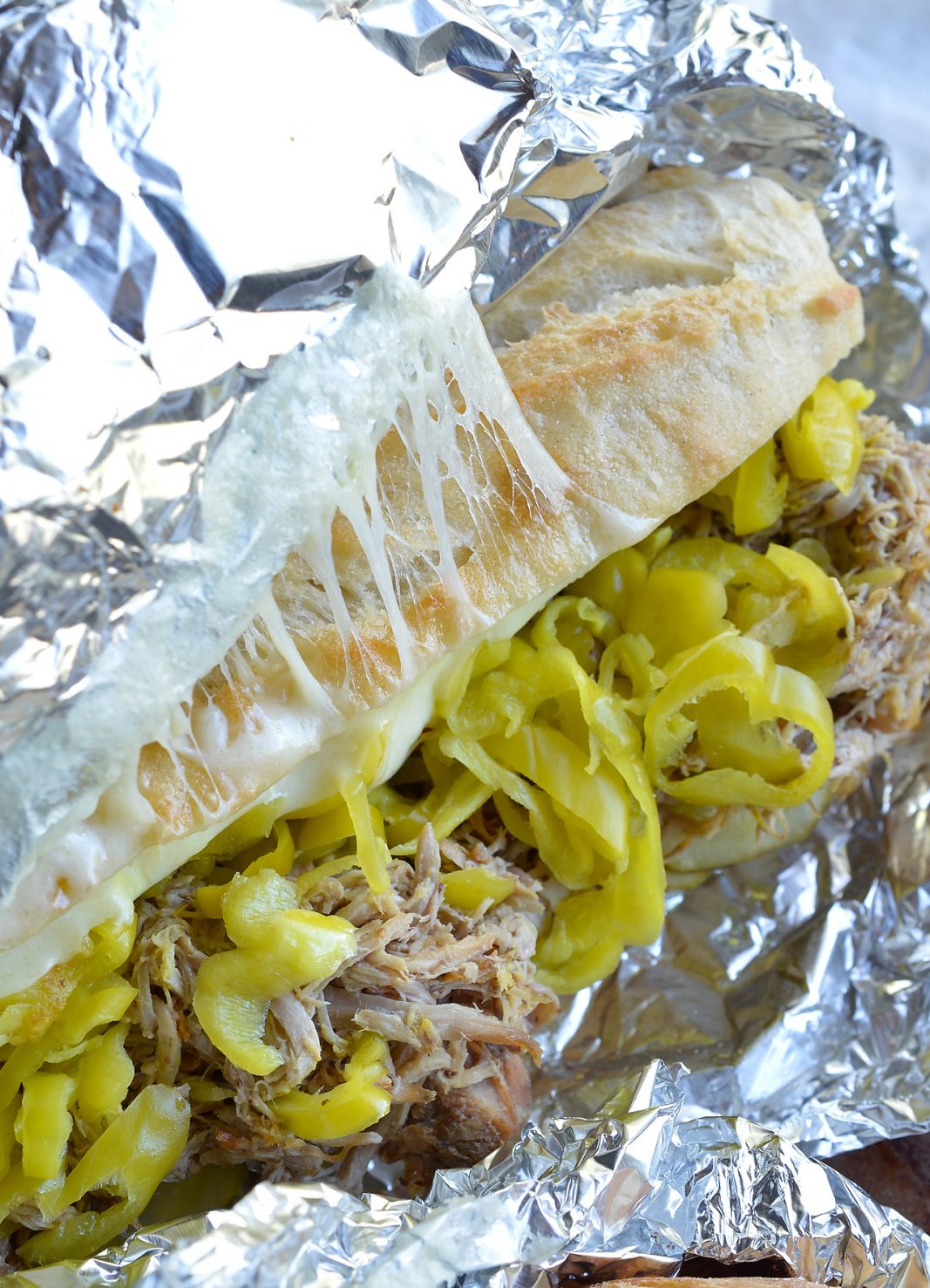 If you are tired of the same old barbecue pork sandwiches give these Slow Cooker Pulled Pork Cuban Sandwiches a try! This easy dinner recipe is inspired by Cuban Sandwiches. Start with Coca-Cola slow cooker pulled pork then add cheese, pepperoncinis, pickles, mustard and bread. These oven baked sandwiches are perfect for feeding a crowd!
