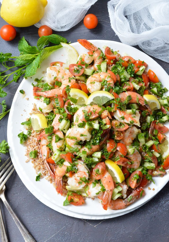 shrimp salad with mint and parsley served on white plate