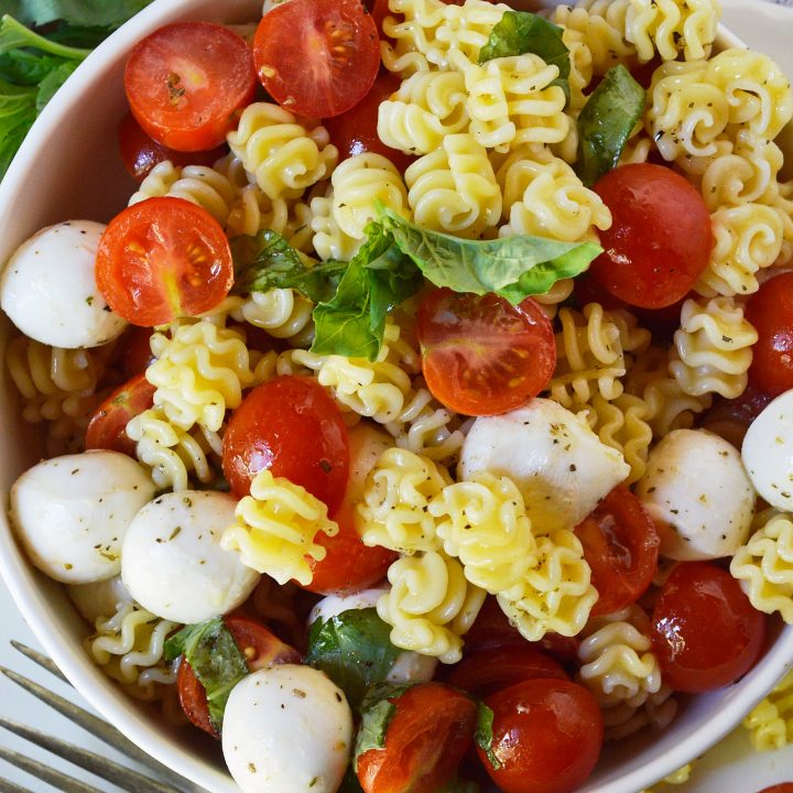Caprese Pasta Salad Recipe is a simple yet flavorful side dish. This pasta salad is filled with mozzarella, tomatoes and basil. Tossed with an Italian oil dressing and topped with balsamic glaze.