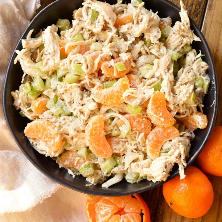 chicken salad With celery chunks and mandarin segments in black bowl