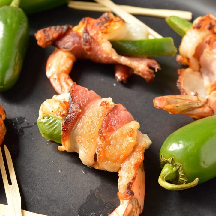close up of bacon wrapped shrimp next to jalapeños